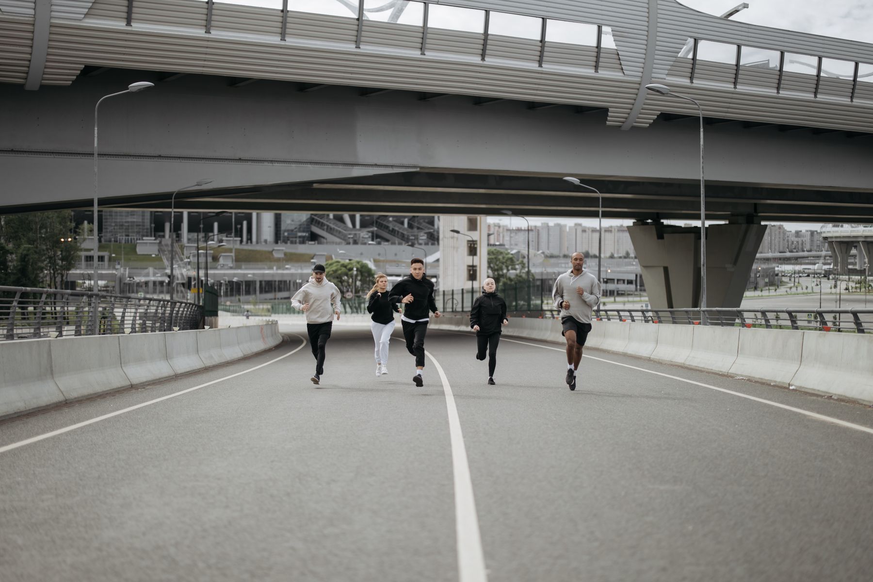 Group of people running together on a city road